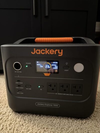 Jackery Explorer 1000 portable power station with front display showing 23 percent battery indoors