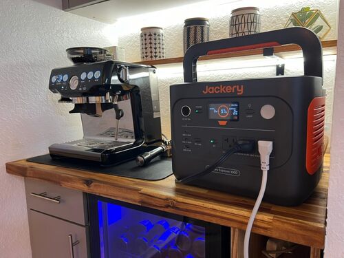 Jackery Explorer 1000 portable power station powering an espresso machine on a kitchen counter
