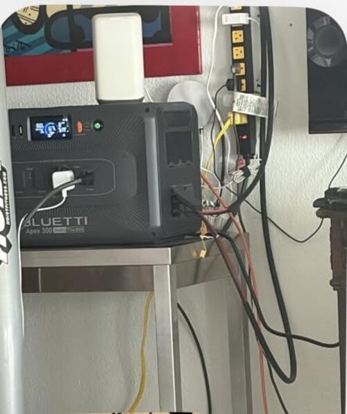 BLUETTI Apex 300 powering home electronics on a shelf during indoor backup use