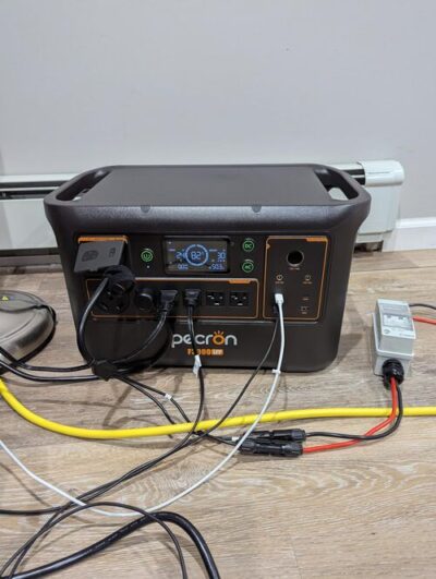Pecron F3000LFP power station running multiple connected devices indoors with AC and DC cables plugged in