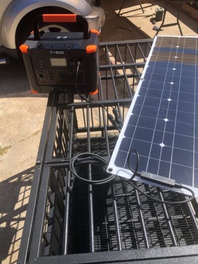 GRECELL T-500 power station charging from a portable solar panel outdoors
