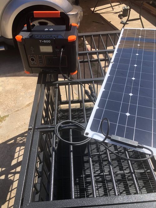 GRECELL T-500 power station charging from a portable solar panel outdoors
