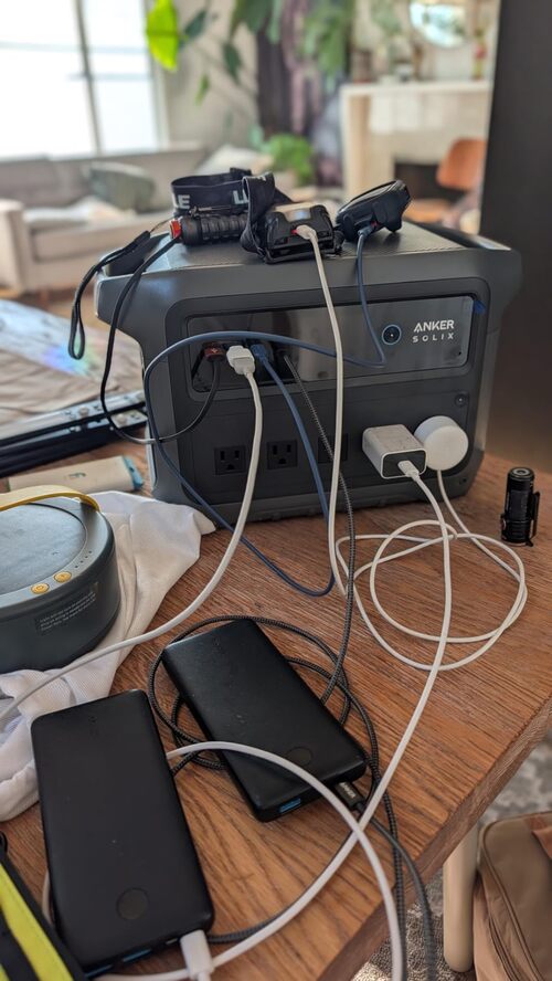Anker SOLIX power station powering phones, lights, and small devices indoors