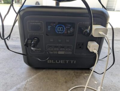 BLUETTI Elite 100 V2 powering multiple devices through AC, USB-C, and 12V DC ports during outdoor use