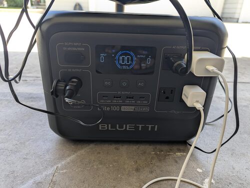 BLUETTI Elite 100 V2 powering multiple devices through AC, USB-C, and 12V DC ports during outdoor use