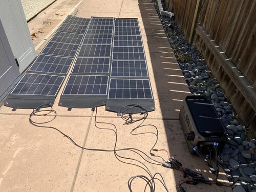 DJI Power 1000 V2 charging from multiple portable solar panels outdoors on a sunny patio