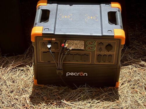 Pecron E3600LFP portable power station outdoors with multiple cables plugged into the front ports