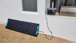 Anker SOLIX C1000 on a windowsill connected to a solar panel outside