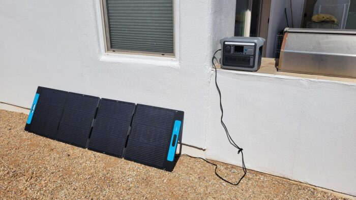 Anker SOLIX C1000 on a windowsill connected to a solar panel outside