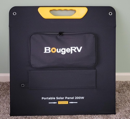 BougeRV FS200W 200W portable solar panel folded and standing upright showing the zippered rear cable pouch, yellow carry handle, and grommets