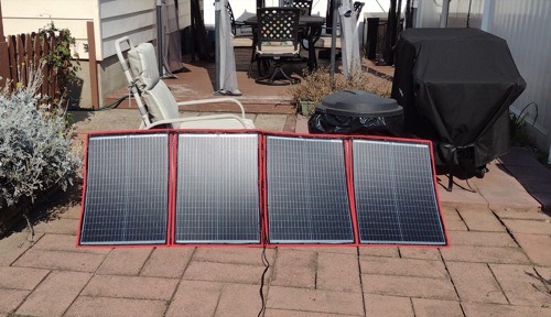 DOKIO 100W four-fold solar panel laid flat on a brick patio in full midday sun