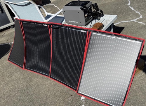 DOKIO 100W four-panel array on pavement connected to a portable power station for solar charging