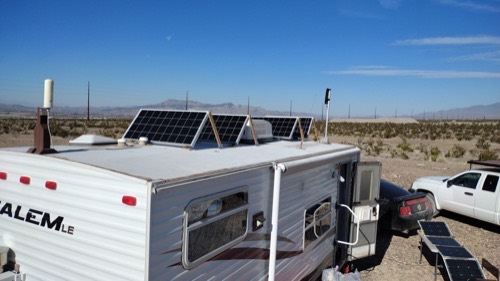 ECO-WORTHY 200W solar panels tilted on a homemade frame atop an RV roof in the desert under clear blue sky