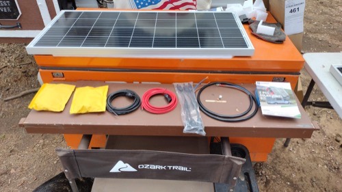 ECO-WORTHY 200W solar panel kit unboxed showing a monocrystalline panel, MC4 solar cables, connectors, mounting hardware, and the instruction manual