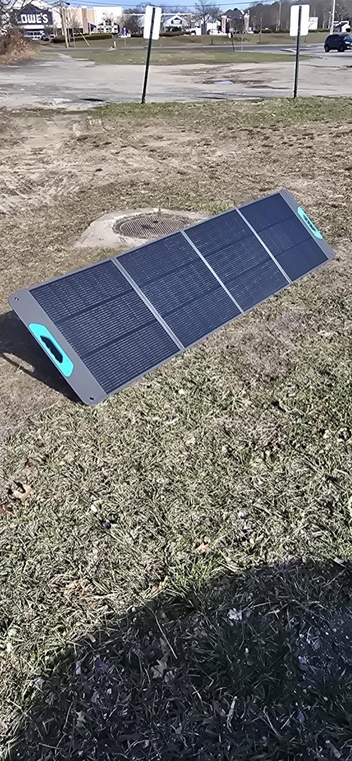 Renogy RPP200EF-SE portable solar panel standing on its kickstand outdoors on dry grass