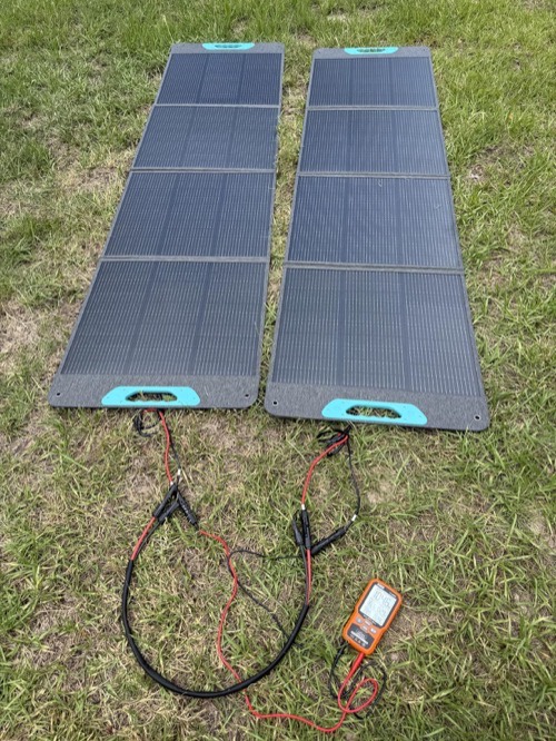 Two Renogy RPP200EF-SE 200W solar panels connected in parallel on grass with a charge meter
