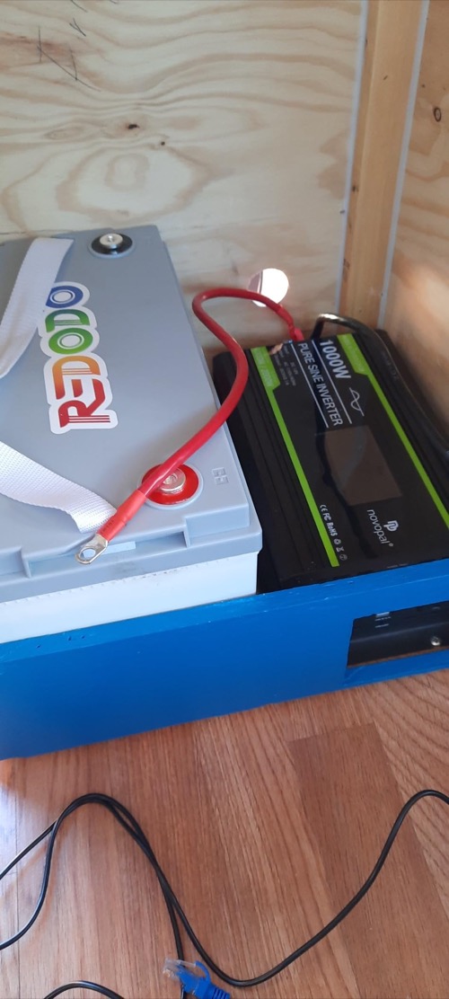 Redodo 12V 100Ah battery installed beside a 1000W inverter