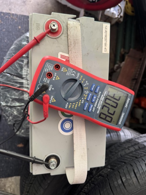 Redodo battery with a multimeter showing voltage