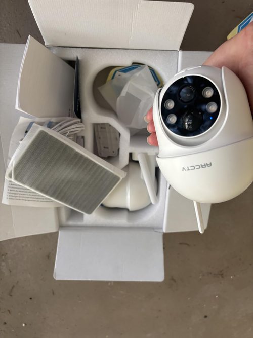 ARCCTV Q01 customer unboxing showing a camera and separate solar panels