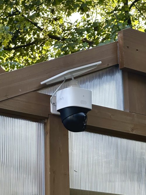 Customer-mounted Eufy SoloCam S340 beneath a wooden beam with its panel above