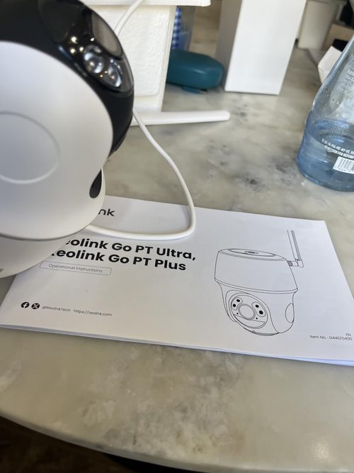Customer photo of a Reolink Go PT Ultra camera beside its shared Ultra and Plus manual