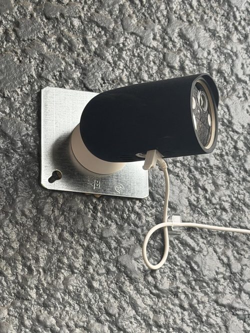 Tapo C460 attached to a customer's patio wall with the panel positioned separately